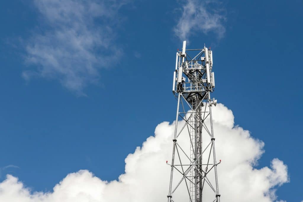 Bottom perspective pov of modern metal steel mobile 5g network wireless telecom tower against clear