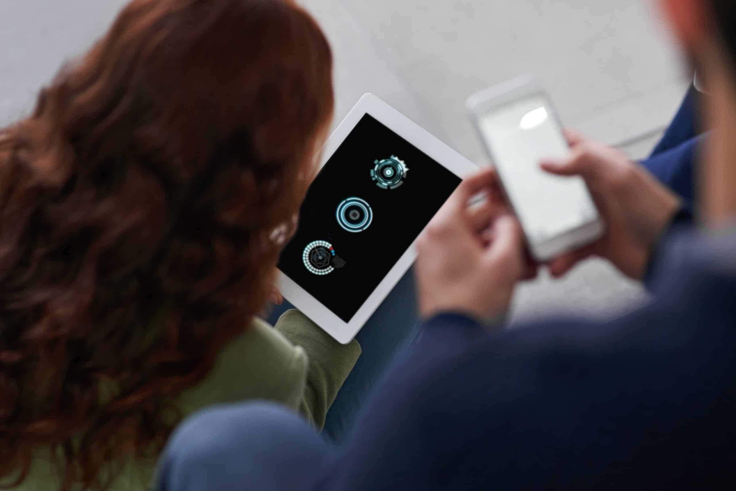 Shot of two business people using a cellphone and a tablet in an office. robust access control system